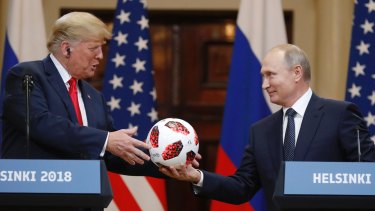 Russian President Vladimir Putin gives a soccer ball to US President Donald Trump in Helsinki, Finland. Trump said he believed Putin's denial of meddling in the elections.