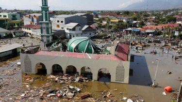 People survey the mosque damaged following earthquakes and tsunami in Palu, Central Sulawesi.