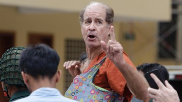 Australian filmmaker James Ricketson gestures as he is escorted by prison guards in January.