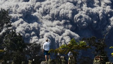 Jack Jones at a country club in Volcano, Hawaii, as a huge ash plume rises from the summit of Kiluaea volcano on May 21.