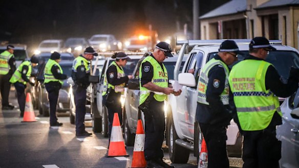 Police stop and question drivers at the NSW-Victorian border.