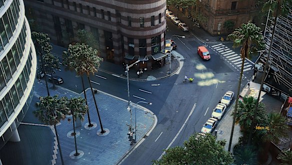 A man pushes a trolley across a near-empty Sydney CBD street. Economists say after virus restrictions pass, governments will have to look at stimulus to re-boot the economy.
