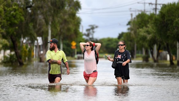 Residents wade through flood water in Townsville in February.