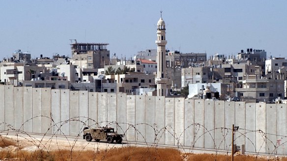 An Israeli army vehicle patrols along Israel’s separation barrier.