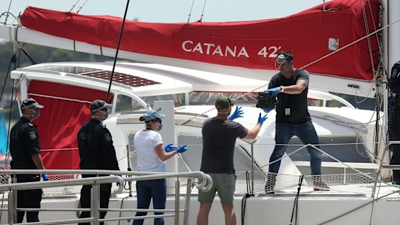 Police moving the cocaine off the yacht at Lake Macquarie.