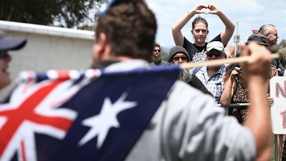 A supporter of the Rally Against Racism responds to a Reclaim Australia Rally supporter, in front of Parliament House in Canberra in 2015. 