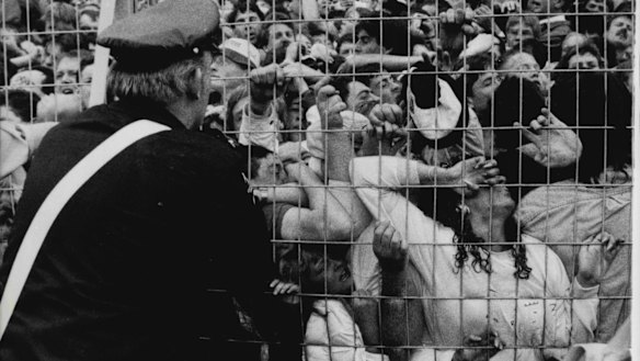 An ambulance worker looks on as Liverpool fans are crushed against a barrier during the Hillsborough disaster.