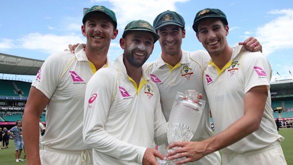 Australian bowlers Josh Hazlewood, left, Nathan Lyon, Mitchell Starc and Pat Cummins hold the Ashes trophy in January.