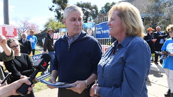 Nationals leader Michael McCormack hands out how-to- vote cards with the Liberal's Julia Ham.