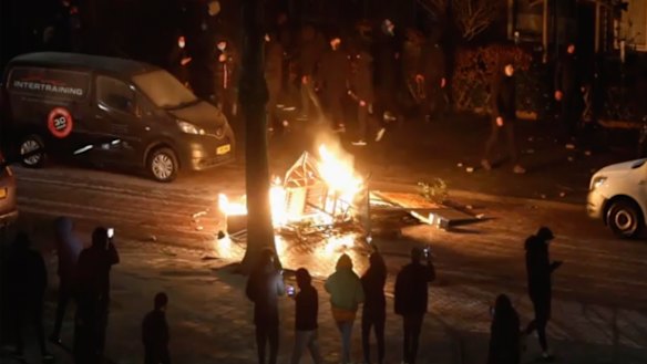 People use their phones to film items burning on a fire started by rioters, in Haarlem, Netherlands. 