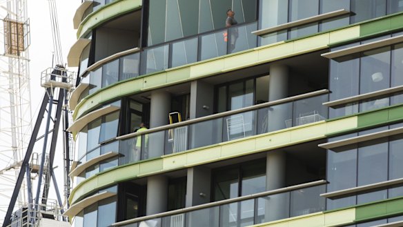 Tradesmen work on Opal Tower in Olympic Park which was evacuated in December.