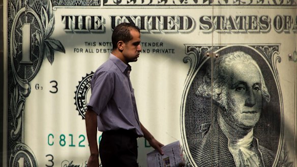 A man walking past a currency exchange office in Cairo. The greenback’s status as the world’s reserve currency is in danger as the the world's largest economy is in turmoil.