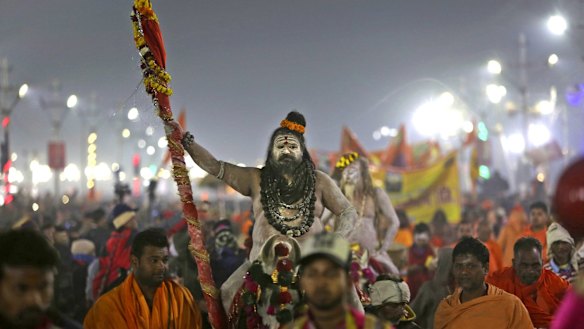 Naked ash-smeared Naga Sadhus or Hindu holy men arrive for a dip.