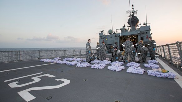 Crew members of HMAS Warramunga lay parcels of seized heroin on the flight deck of the ship during an operation in the Western Indian Ocean, seizing 915kg of heroin valued at more than AUD$274 million in January 2018.
