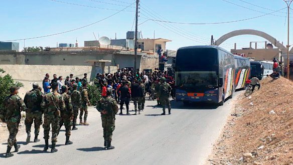 This photo released by the Syrian official news agency SANA, shows Syrian government forces overseeing the evacuation by bus of rebels and their family from the towns of Ruhaiba in the eastern Qalamoun region in the Damascus countryside.