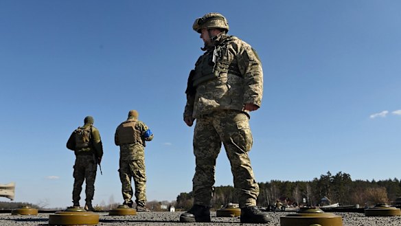 Commander Sulyemnko (right) with the 72nd Brigade standing on a destroyed bridge laid with anti tank mines, east of Kyiv, Ukraine.