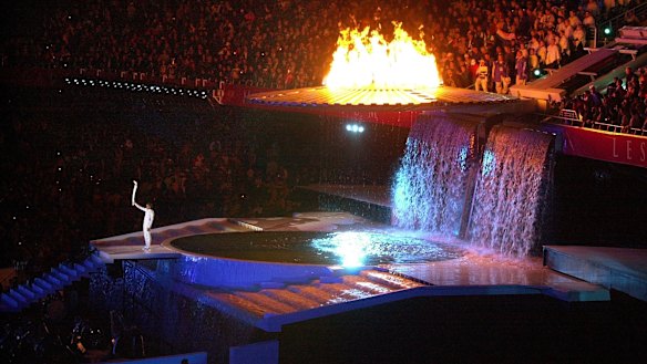 Cathy Freeman holds up the Olympic torch at the end of the opening ceremony of the 2000 Olympics in Sydney.  (AP Photo/Laura Rauch)