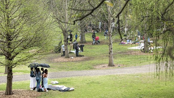 Picnics are packed up as the rain begins to fall at Centennial Park.