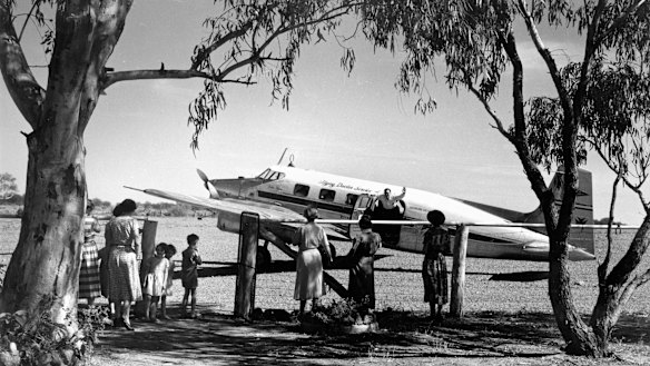 Flying Doctor being greeted by a group of waiting women and children