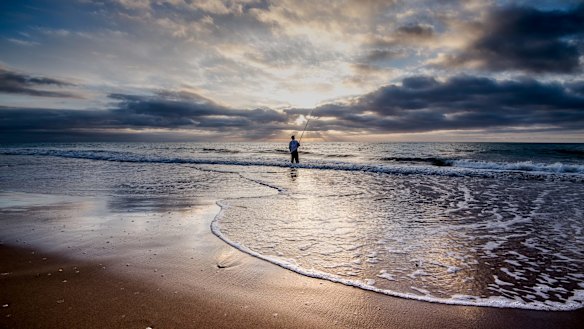 A fisherman at dawn on Paradise Beach.