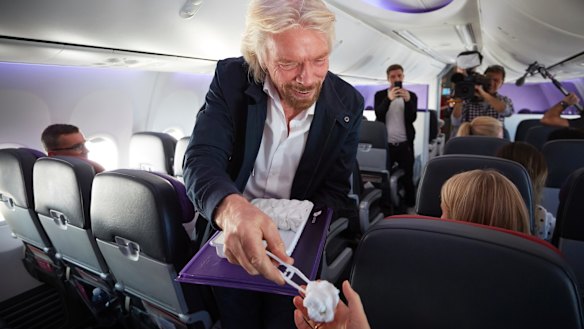 Towel boy: Sir Richard Branson handing The Goss a hot towel on the world's first dedicated meditation flight on Thursday.