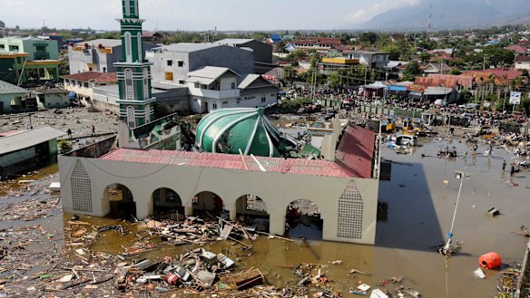 People survey the mosque damaged following earthquakes and tsunami in Palu, Central Sulawesi.
