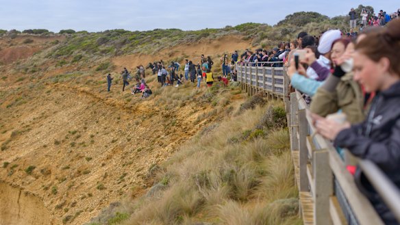 Tourists pose for photos outside the designated viewing area for the Twelve Apostles at Port Campbell. 