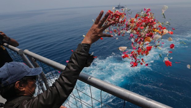 A relative sprinkles flowers for the victims of the crashed Lion Air flight 610 from an Indonesia Navy ship in the waters where the plane is believed to have crashed.