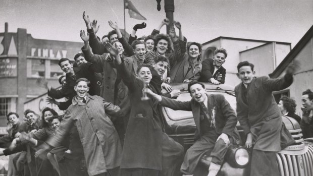 Crowds of women and boys on factory trucks in Elizabeth Street celebrate the victory in Europe.
