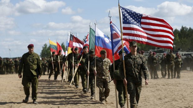 A Slovenian, third in line, joins fellow soldiers from NATO countries - including US, UK, and Canada, at  the opening ceremony of military exercise "Sabre Strike 2015".