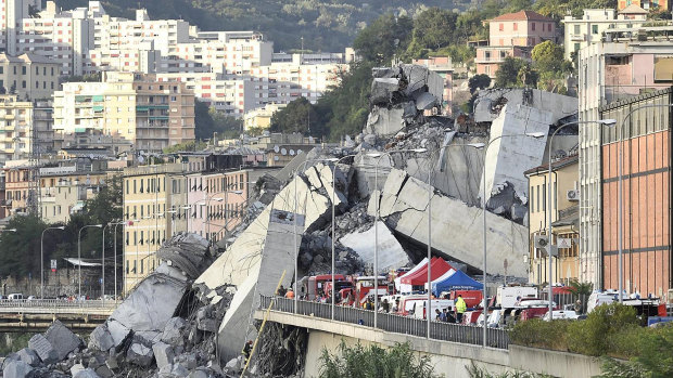 Rescuers work to recover an injured person after the Morandi highway bridge collapsed in Genoa, northern Italy, on Tuesday.