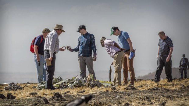 Foreign investigators examine wreckage at the scene where the Ethiopian Airlines Boeing 737 Max 8 crashed.