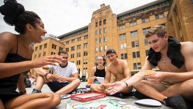 German backpackers get involved in a game of Monopoly in front of the MCA as they wait for the fireworks.