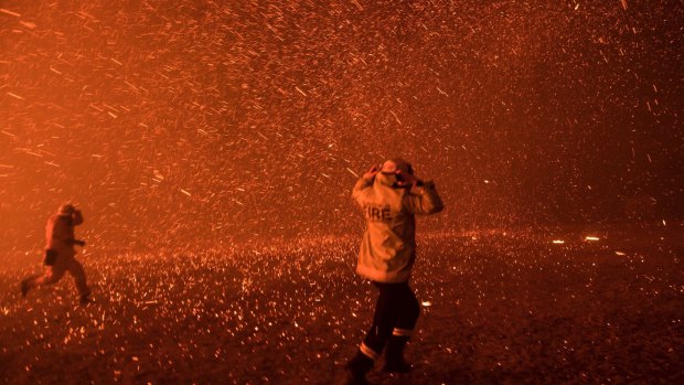 Firefighters run for safety as the Green Wattle Creek fire explodes into a sudden ember storm in Orangeville.