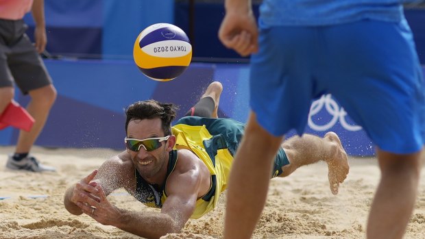 Damian Schumann, of Australia, dives for the ball during a men’s beach volleyball match against the ROC team on Monday.