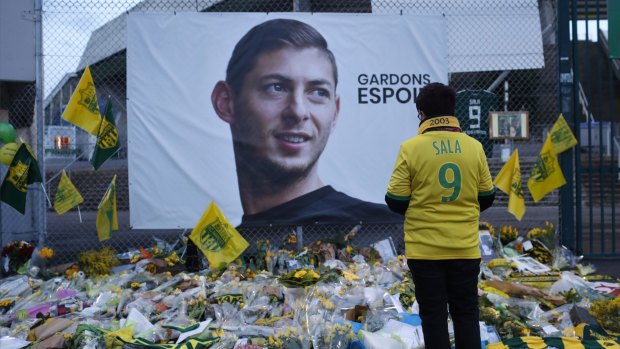 A  Nantes  supporter  stops by a poster of Argentinian player Emiliano Sala " outside La Beaujoire stadium. 