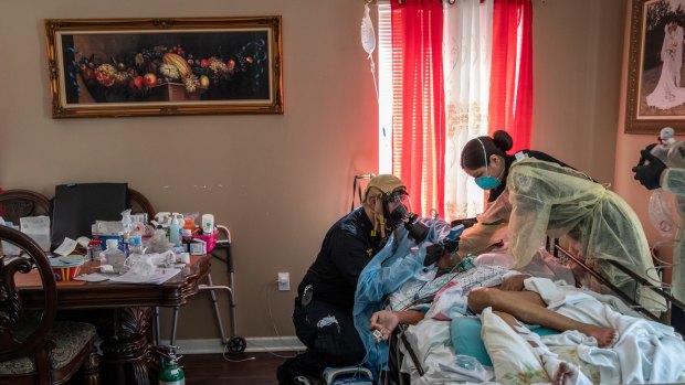 Medics intubate a gravely ill patient with COVID-19 symptoms at his home in New York in April 2020.
