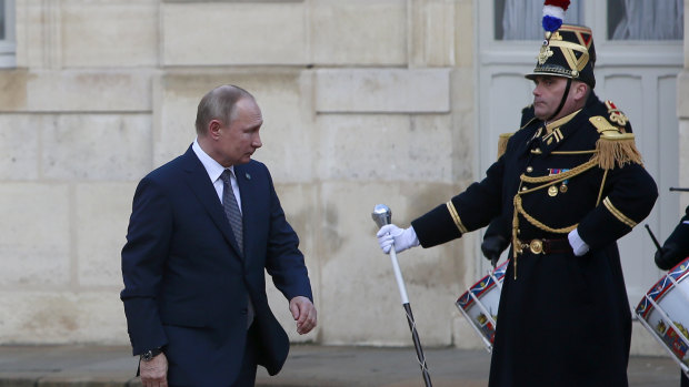 Russian President Vladimir Putin walks past Republican guards as he arrives at the Elysee Palace for Ukraine talks on Monday.