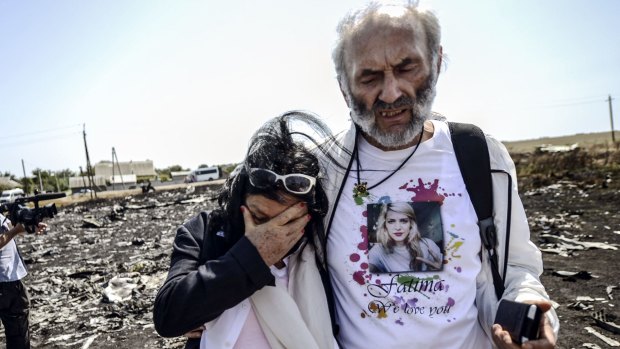 Perth couple Jerzy "George" Dyczynski and Angela Rudhart-Dyczynski look over the wreckage of the crashed aircraft in Ukraine.