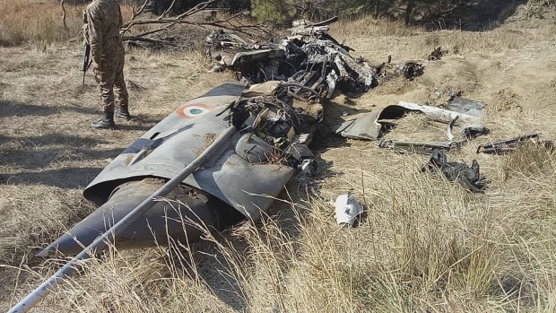 A Pakistani soldier stands guard near the wreckage of an Indian plane shot down by the Pakistan military.