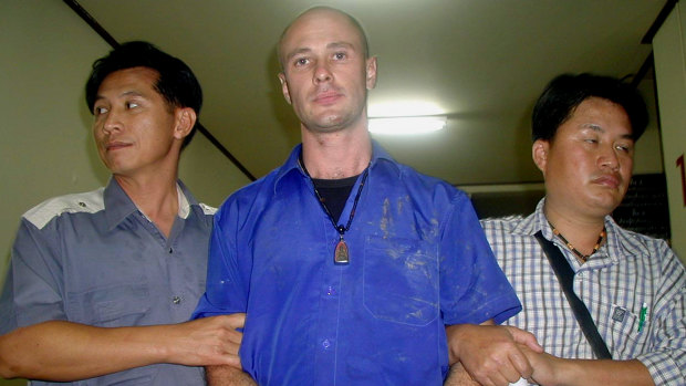 Mizner pictured in 2006 being escorted by Thai police in Chiang Mai, north of Bangkok. 