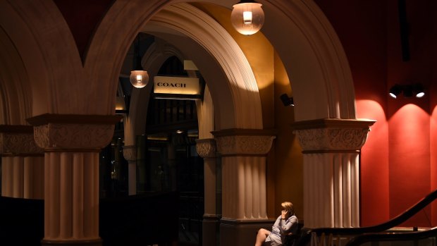 A woman talks on the phone in a normally busy Queen Victoria Building.