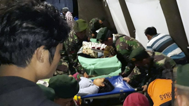 Indonesian soldiers tend to a woman injured in the earthquake at a makeshift hospital in Lombok.