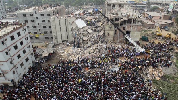 People gather as rescuers look for survivors and victims at the site of the Rana Plaza collapse.