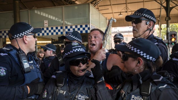 Police led a far-right nationalist away from Invasion Day protesters at Flinders Street Station.