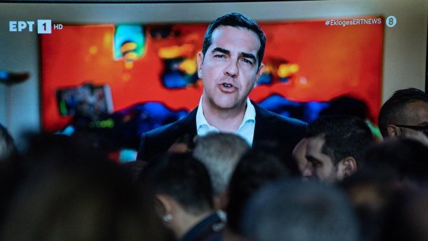 Yunanistan'da Syriza partisinin lideri Alexis Tsipras Pazar günü bir taviz konuşması yaparken bir televizyonda gösteriliyor.
