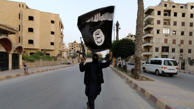 A member of Islamic State waves an IS flag in Raqqa, Syria.