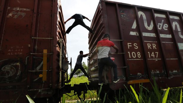 Migrants catch a ride on a freight train on their way north to the US, in Salto del Agua, Chiapas state, Mexico, on Tuesday.