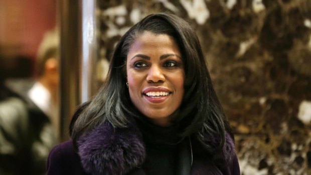 Omarosa Manigault smiles at reporters as she walks through the lobby of Trump Tower in New York.