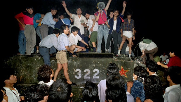 Civilians stand on a government armored vehicle near Changan Boulevard in Beijing.